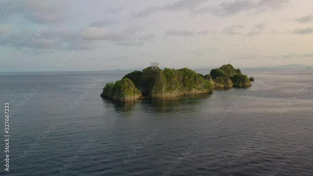 An aerial view shows rugged limestone islands rising from the seascape near Penemu, Raja Ampat, Indonesia. This area is well known by divers and snorkelers for its amazing marine biodiversity. An aerial view shows rugged limestone islands rising from the seascape near Penemu, Raja Ampat, Indonesia. This area is well known by divers and snorkelers for its amazing marine biodiversity.