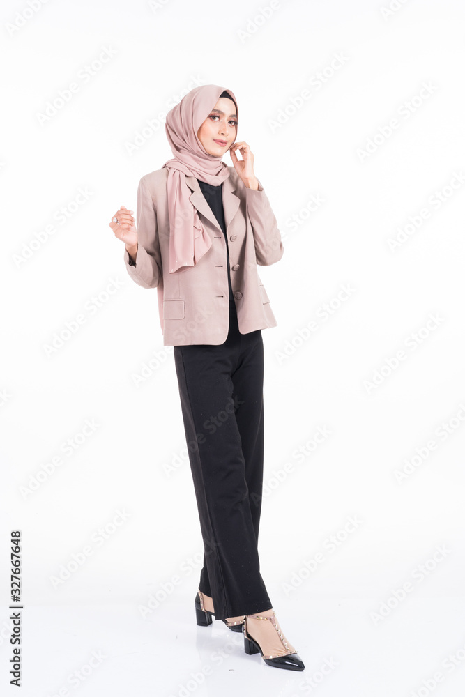 Full length portrait of a beautiful Muslim female model in a hijab and officewear isolated on grey background. Hijab and Muslim fashion lifestyle concept Full length portrait of a beautiful Muslim female model in a hijab and officewear isolated on grey background. Hijab and Muslim fashion lifestyle concept