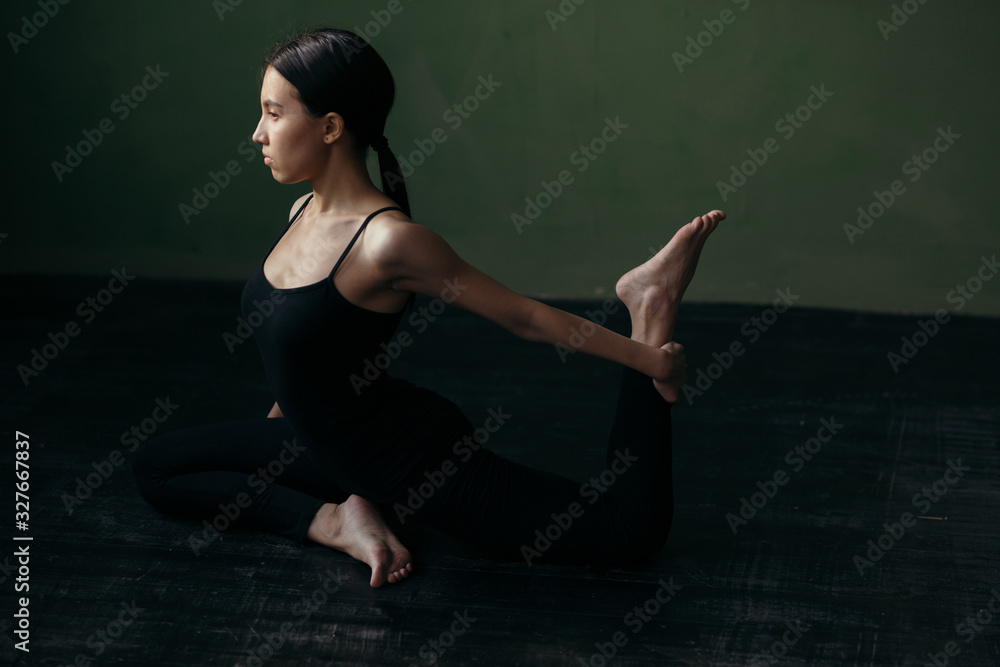 Girl is doing stretching exercise. Yoga class in black sportswear. Girl is doing stretching exercise. Yoga class in black sportswear.
