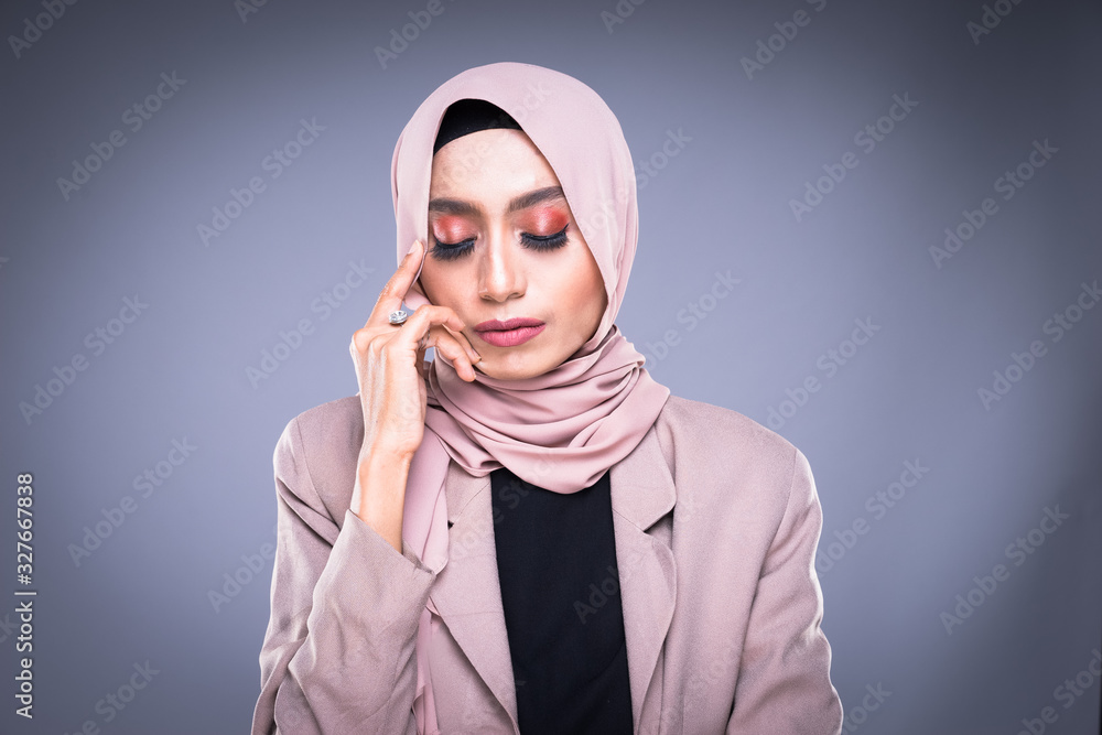 Headshot of a beautiful Muslim female model in a hijab and officewear isolated on grey background. Hijab and Muslim fashion lifestyle concept Headshot of a beautiful Muslim female model in a hijab and officewear isolated on grey background. Hijab and Muslim fashion lifestyle concept