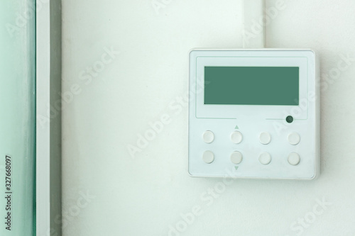 white wall air conditioning control panel with screen and control buttons, close up empty.