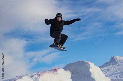 snowboarder and skier skiing on a ski slope, front and background blurred