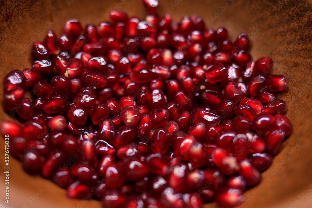 pomegranate seeds in a brown plate pomegranate seeds in a brown plate