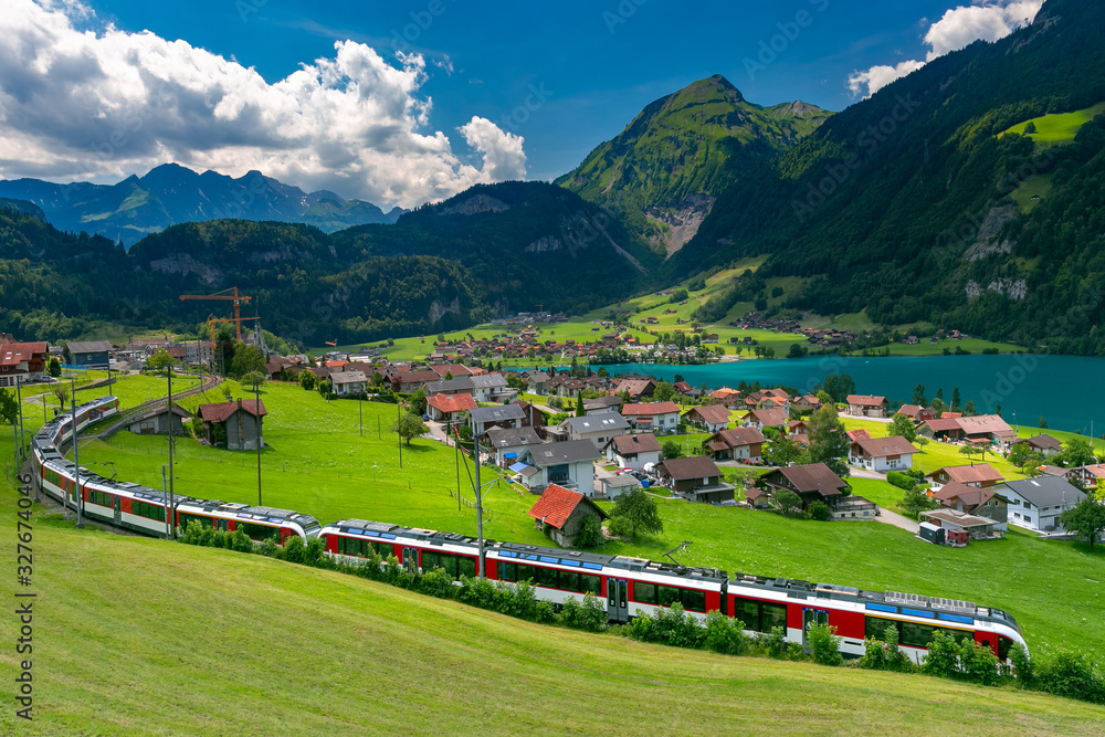 Famous electric red tourist panoramic train in swiss village Lungern, canton of Obwalden, Switzerland