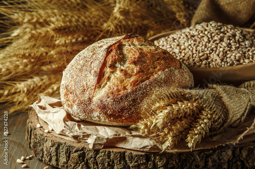 Freshly baked traditional bread on wooden table, with copy space, food closeup. Whole grain rye bread with seeds