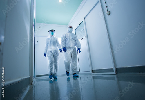 Biologist in protective clothing in laboratory hallway