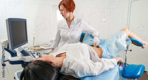 Gynecologist doing ultrasound scanning for pregnant woman photo