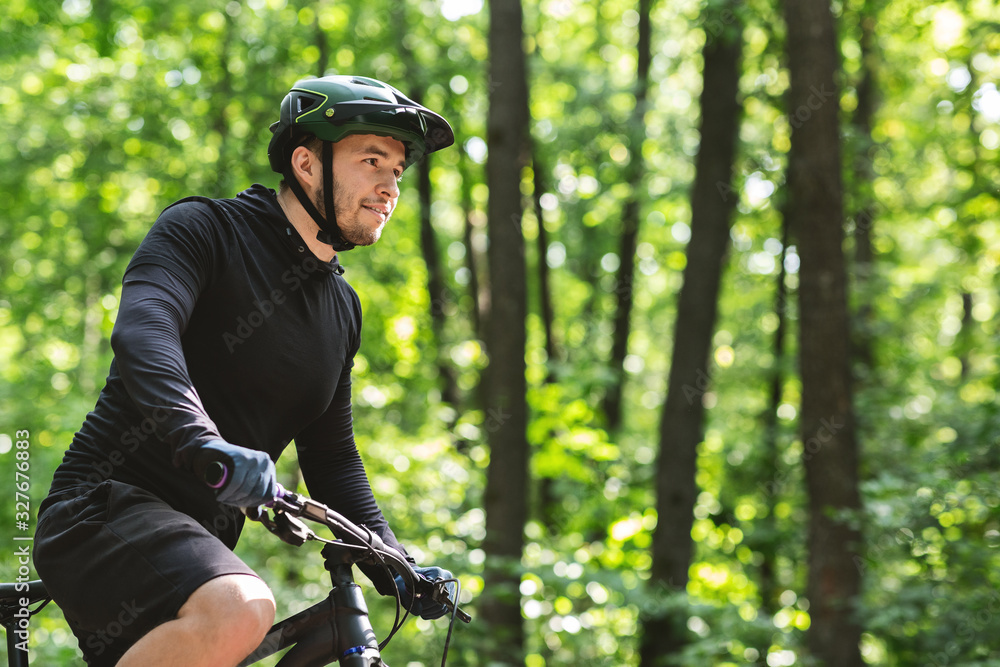 Professional cycler riding sport bike in summer forest Professional cycler riding sport bike in summer forest