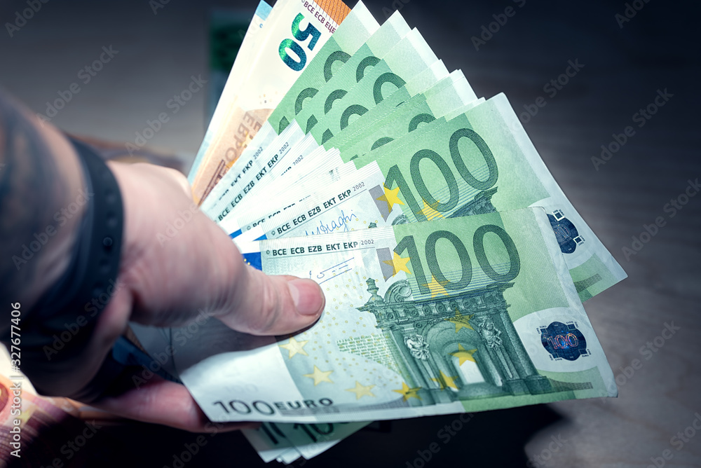Heap of hundred euro banknotes in the hand Heap of hundred euro banknotes in the hand