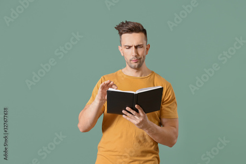 Young man reading book on c...