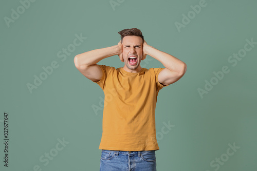 Indignant man covering ears...