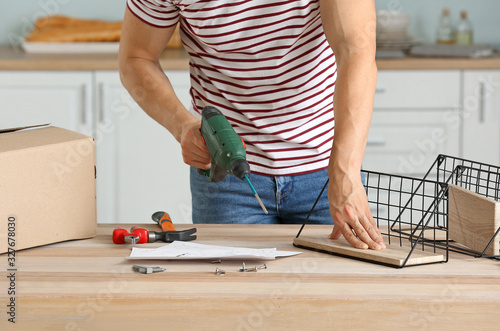 Young man assembling furniture at home © Pixel-Shot
