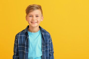 Happy little boy with healthy teeth on color background