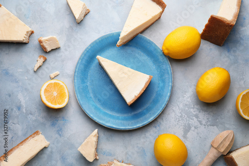 Composition with pieces of sweet tasty cheesecake and lemons on light background