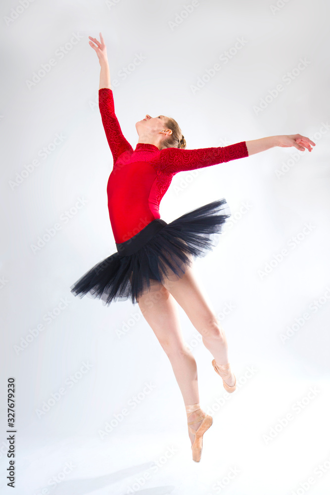 Obraz premium Young woman ballet dancer leaping in a black tutu.
