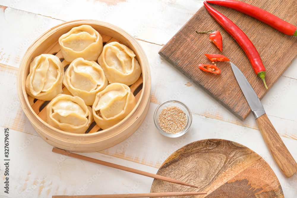 Steamer with oriental dumplings and chili pepper on table Steamer with oriental dumplings and chili pepper on table