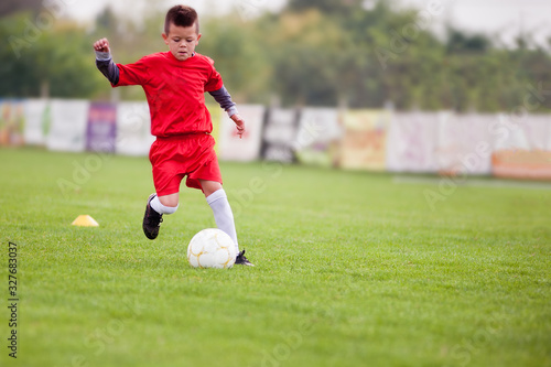 Little soccer player in action with ball © marritch