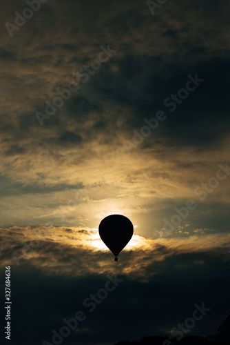 hot air balloon silhouette at sunset. Vertical stock photo. Adventure concept.
