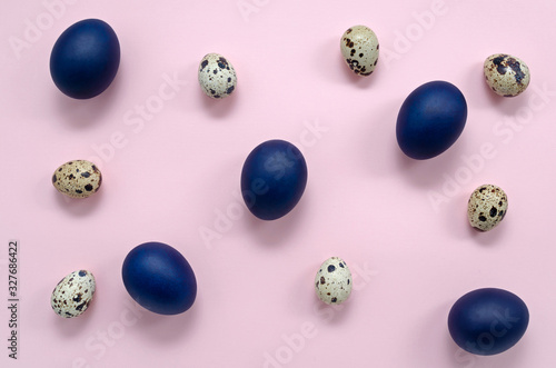 classic blue Easter eggs and quail eggs on a pink background are located evenly throughout the frame. Easter festive romantic concept. photo