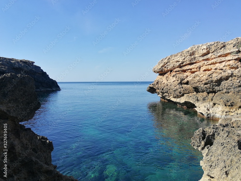 Seaview of the beach of the Mallorca coastline with turquoise waters and blue sky 