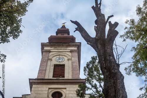 Serbian orthodox Church of Uljma, a 19th century old Austro Hungarian style church, with its typical baroque clocktower. Uljma is a small rural village of the Serbia province of Voivodina photo