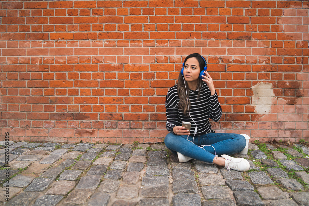 Woman listening music and using smartphone.