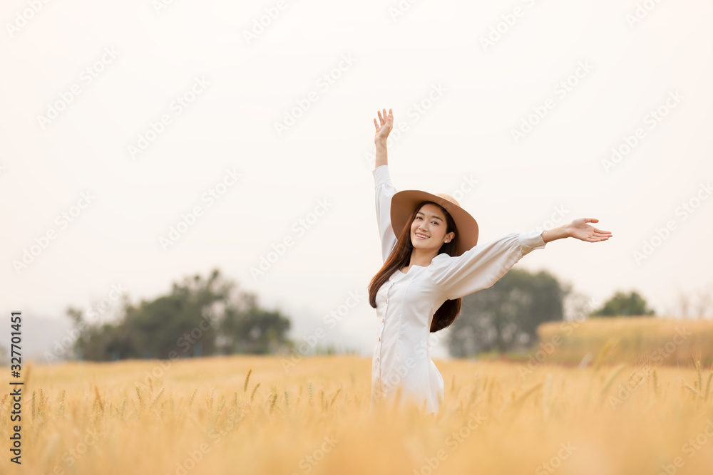 young woman walking in barley field with hat up and having fun. summer vacation. young woman walking in barley field with hat up and having fun. summer vacation.