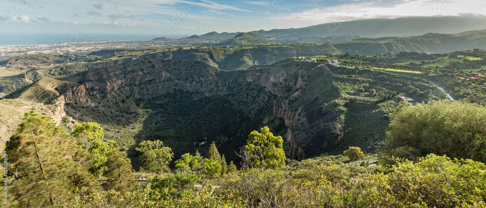 Super wide panorama. Aerial view from Bandama mountain peak to Caldera Bandama. Warm sunny day, bright blue sky and beautiful white clouds. Canary islands, Spain