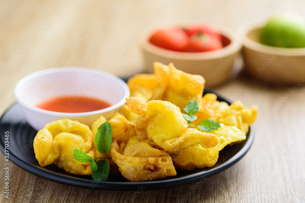 Deep-fried crispy wonton stuffed with minced pork, quail egg and shrimp eating with chili sauce, Asian food Deep-fried crispy wonton stuffed with minced pork, quail egg and shrimp eating with chili sauce, Asian food