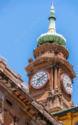 Photography Sydney, Australia - December 11, 2009: Closeup of red-stone clock tower on top of Lands Department Building under blue sky