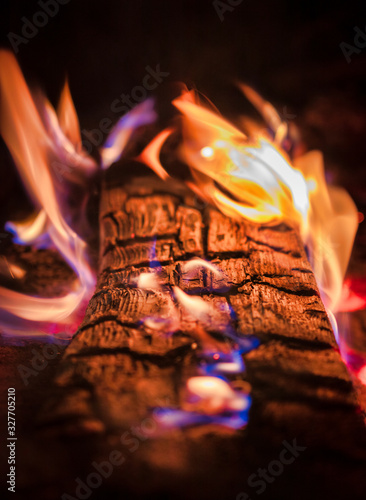 background. black logs burn in an orange flame