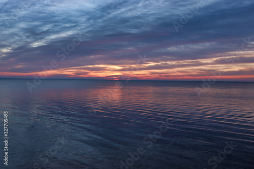 background. Beautiful sunrise / sunset on the sea / lake / river. heavy clouds with an orange tint.