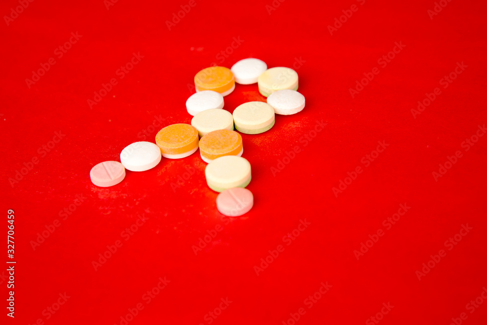 Arranged tablets making shape of a ribbon in red Arranged tablets making shape of a ribbon in red