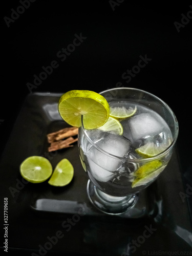 glass of water with lemon and ice on white background