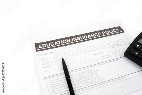 Education insurance policy document beneath a pen