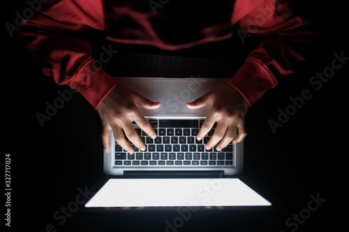  hacker sealing data from laptop at night, close up 