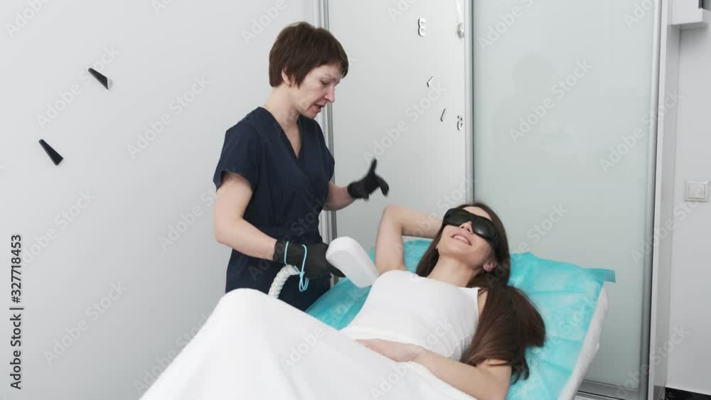 Pretty girl receiving laser hair removal armpit in beauty studio Pretty girl receiving laser hair removal armpit in beauty studio
