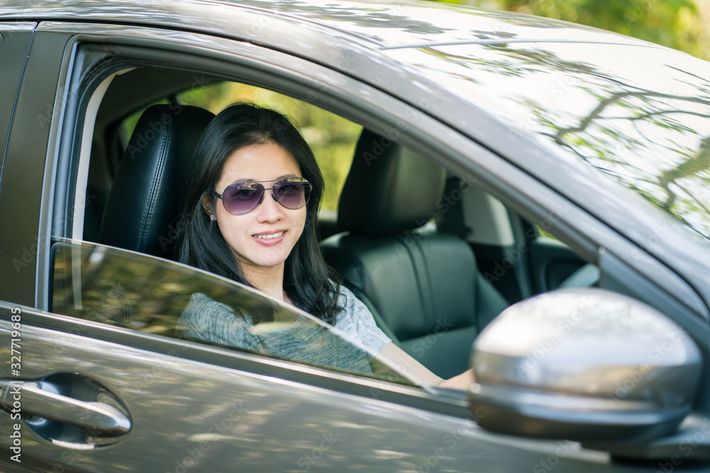 Asian woman driving a car.