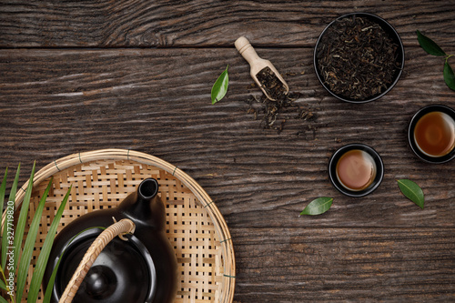 Tea cup with teapot, organic green tea leaves and dried herbs on the wooden desk empty space creative flat lay, Organic product from the nature for healthy with traditional style