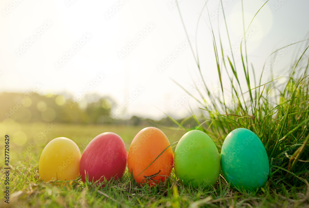 Easter eggs in the lawn with warm orange lighting and bokeh.   