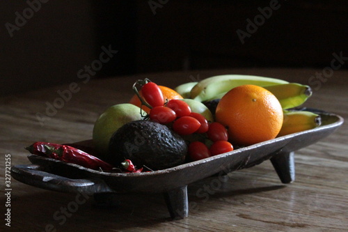 fresh fruit and vegetables displayed on old wooden platter