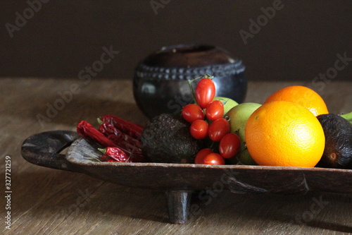 fresh fruit and vegetables displayed on old wooden platter