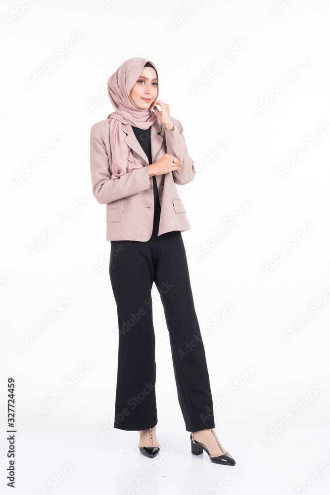 Full length portrait of a beautiful Muslim female model in a hijab and officewear isolated on grey background. Hijab and Muslim fashion lifestyle concept Full length portrait of a beautiful Muslim female model in a hijab and officewear isolated on grey background. Hijab and Muslim fashion lifestyle concept
