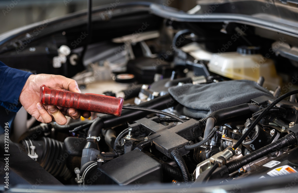Fototapeta premium mechanic hand using Tachometer checking engine of car