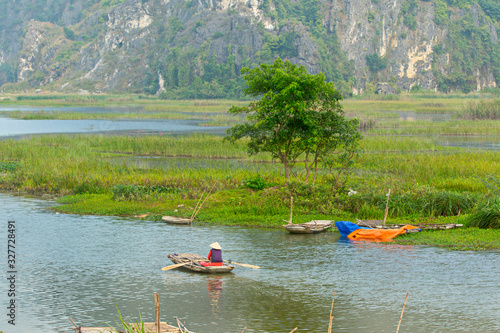 VANLONG NATURAL RESERVE, NINH BINH, VIETNAM - FEBRUARY 29, 2020:   An unidentified woman sailing  a boat on the lagoon. Due to Covid-19 impacts, very few tourists coming to the Reserve. 