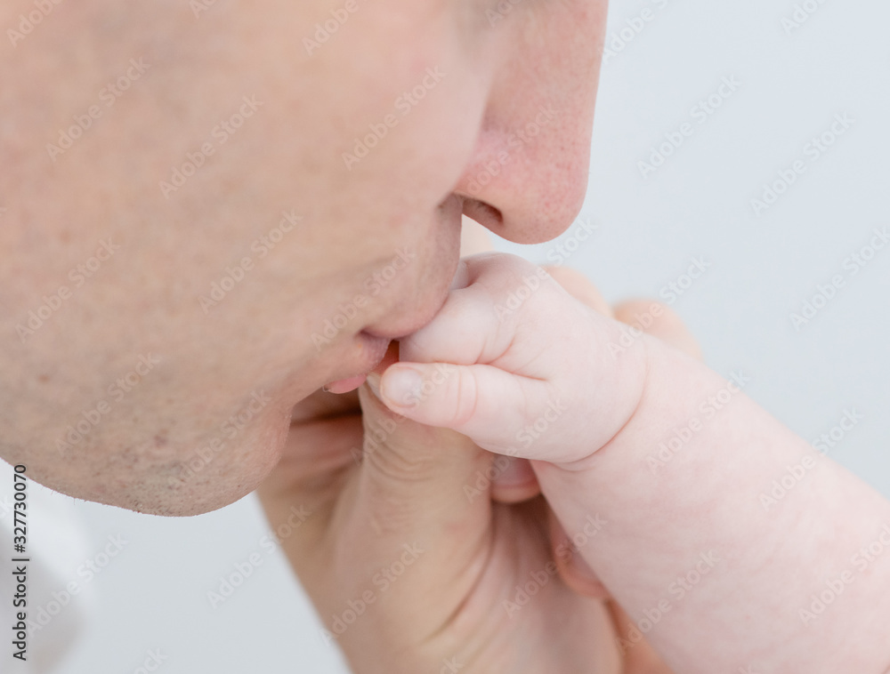 Closeup of father kisses hand his newborn baby Closeup of father kisses hand his newborn baby