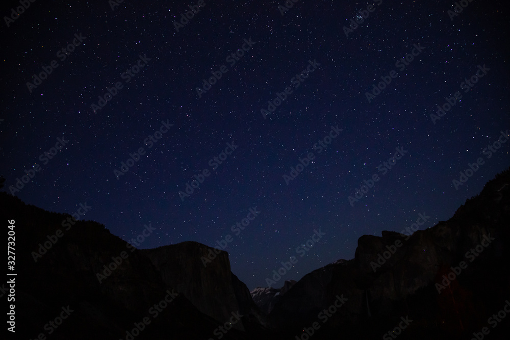 Starry night shot in Yosemite Valley with silhouette of El Capitan and Half Dome