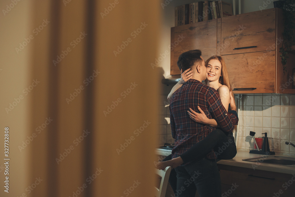 Caucasian couple having joy together in the kitchen during a warm summer morning Caucasian couple having joy together in the kitchen during a warm summer morning