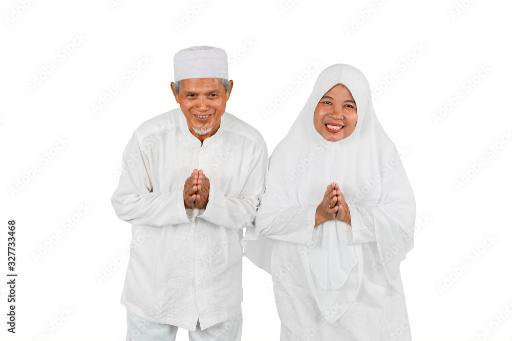 Old couple showing greeting gesture together during Eid Mubarak celebration isolated over white background