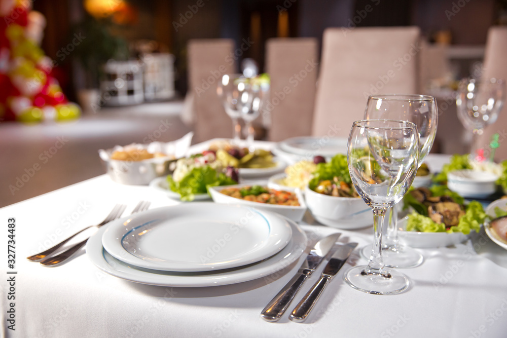 Salads and gums . Set of a dish with spoon, fork and knife on white table.Table setting on white table .